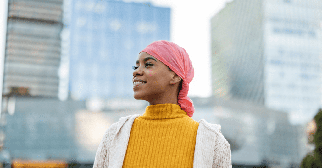 Smiling Black woman wearing a pink head scarf